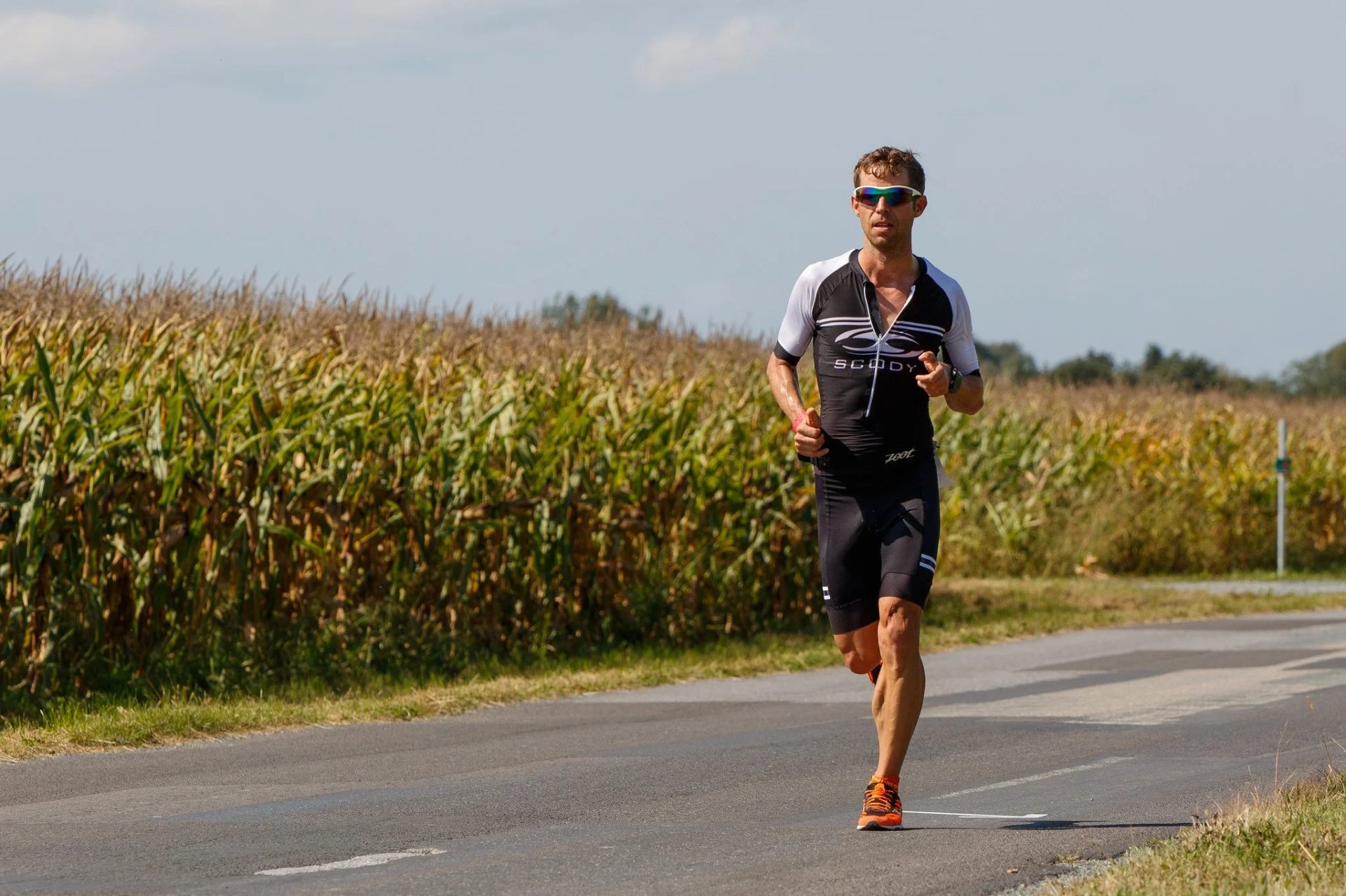 Andy Gesellmann running on a country road past a cornfield